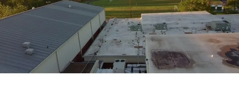 Aged campus roof sections with stained, ponding-prone low spots before repair.