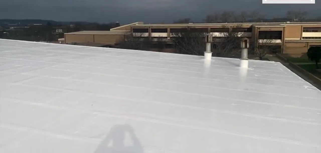 Finished white roof restoration on a Texas Hill Country school gymnasium